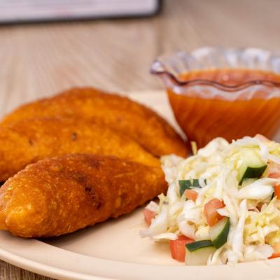 Pastries stuffed with chicken, with tomato sauce and cabbage slaw, closeup