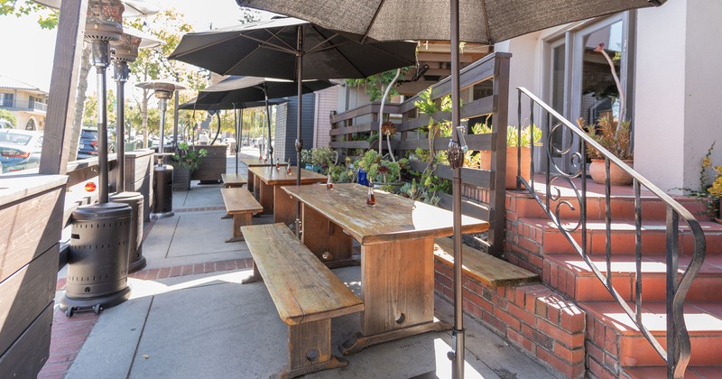 Patio with tables and benches and sunshades umbrellas