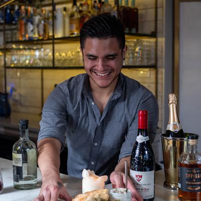 A friendly server places food plates on a bar counter.