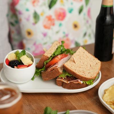 A served club sandwich and other meals and drinks.