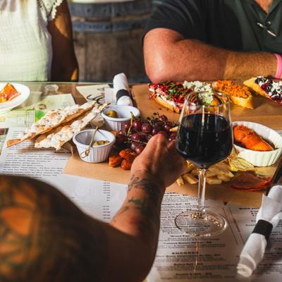 Customers helping themselves to food on a charcuterie board.