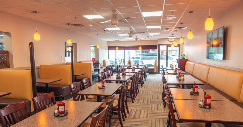 Interior, fully set dining tables, banquette seating, and booths