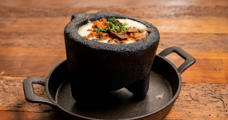 Queso Fundido topped with sautéed mushrooms, chorizo, and fresh cilantro