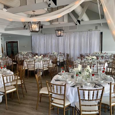 Large reception hall with fully set dining tables.