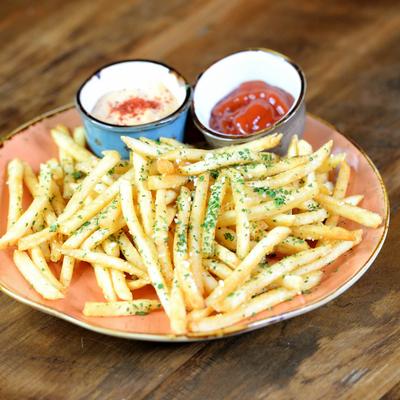 A plate of seasoned fries with ketchup and aioli.