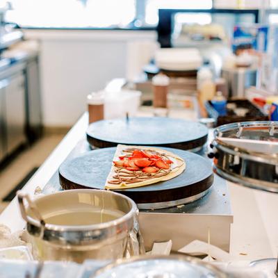 Strawberry and Nutella crepe on a griddle.