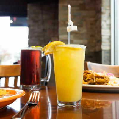 House Margarita, served on the table with glass of beer and food.