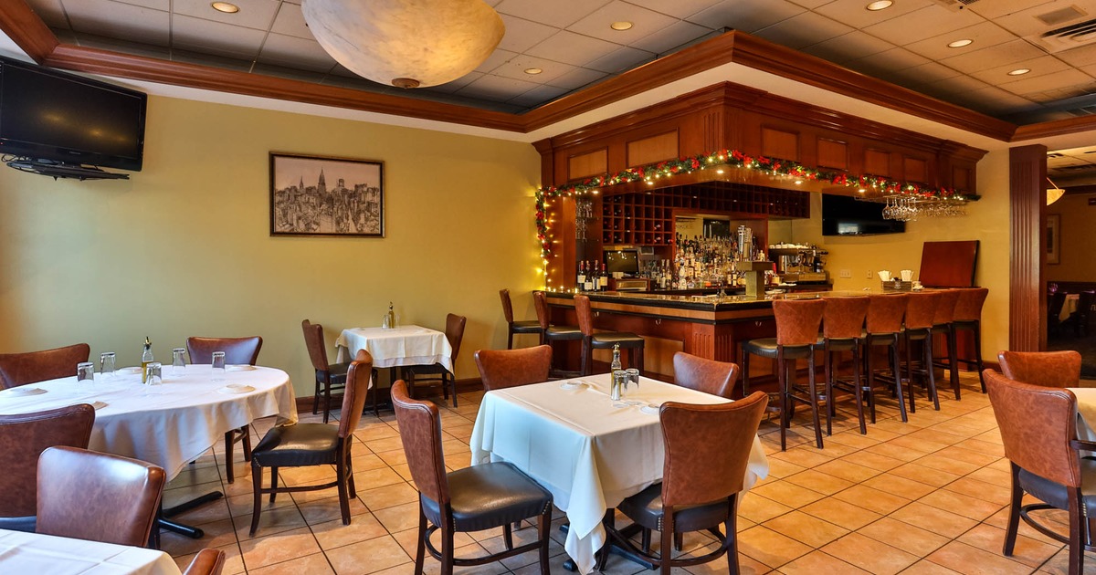 Interior, bar and dining area, tables with chairs, bar with stools in the back