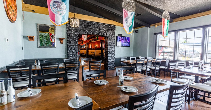 Interior, lined up tables with tableware and cutlery