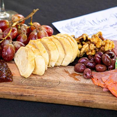 Meat and Cheese Board, with olives, grapes, nuts, fig jam, and baguette.