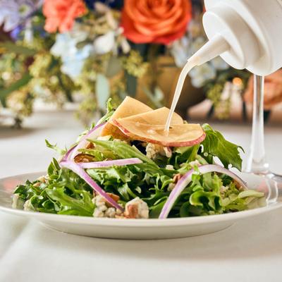 Salad with spring mix, apples, gorgonzola, candied pecans, onion, and vinaigrette.