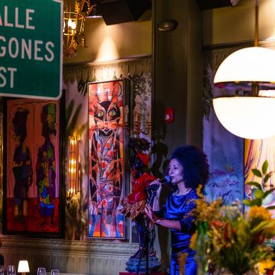Live performance by our singer with colorful artwork visible behind her.