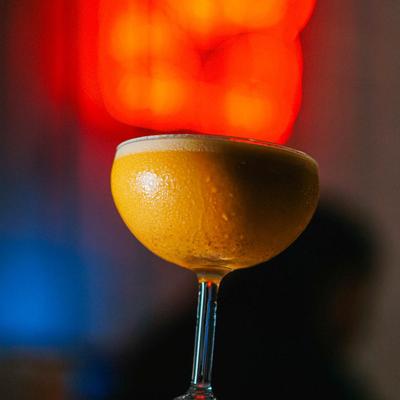 Frothy, tropical passion fruit cocktail served in a stemmed coupe.
