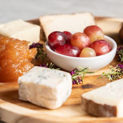 Assorted Cheese Platter with four types of cheese, jam, grapes, and bread
