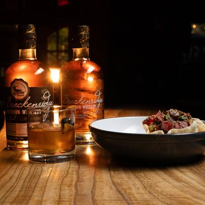 Sesame Seed Tuna plate and whiskey bottles on a wooden table.