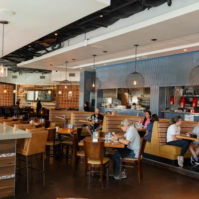 People sitting in boots and at tables in the dinning area.