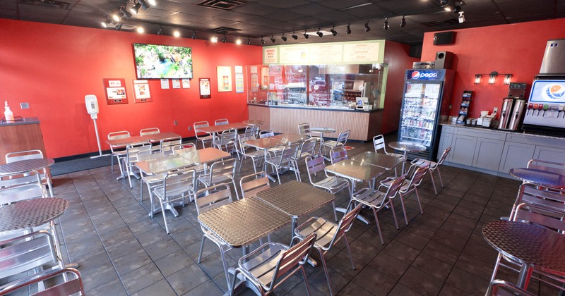 Interior, dining area, tables with chairs for four and two, kitchen in the back