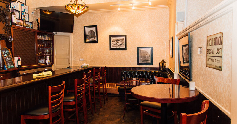 Interior, bar with high chairs on the left and tables on the right