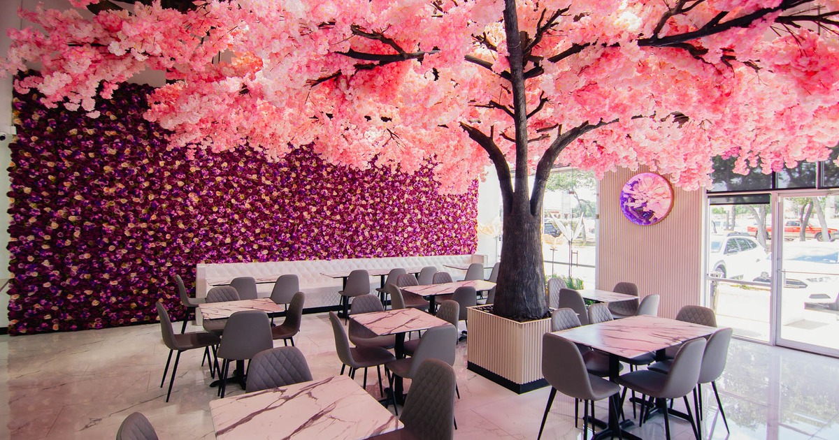 Interior, seating area with tables, chairs, and a cherry blossom tree as the centerpiece