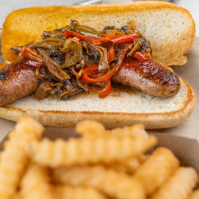 Sausage sandwich, with caramelized onions, peppers, and fries.