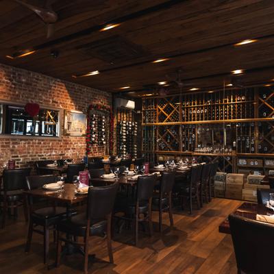 Spacious restaurant interior with wooden floors and wine wall.