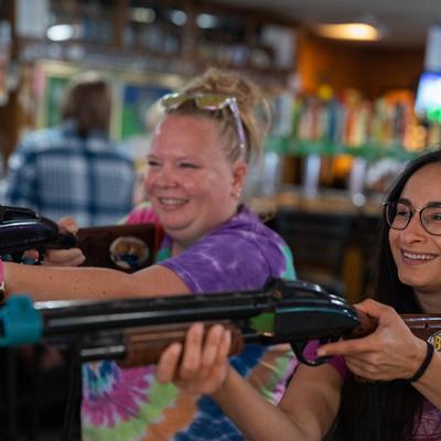 A couple of guests playing Big Buck Hunter game.