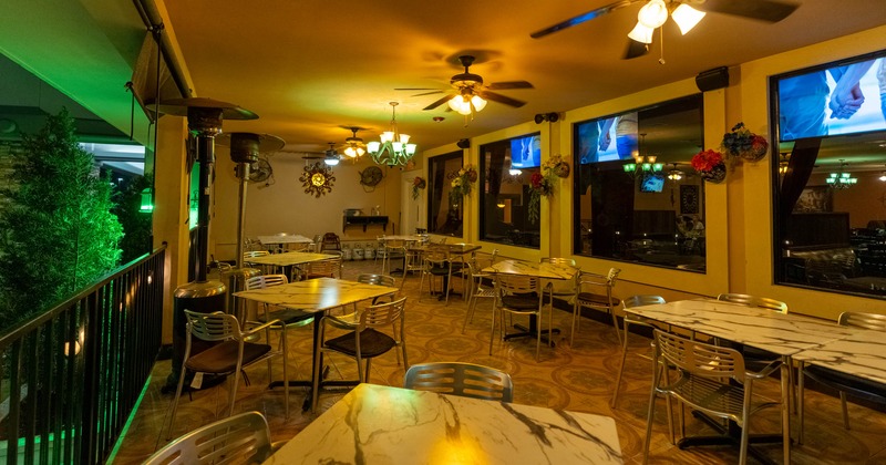 Restaurant interior with marble tables, metal chairs, and decorative lighting