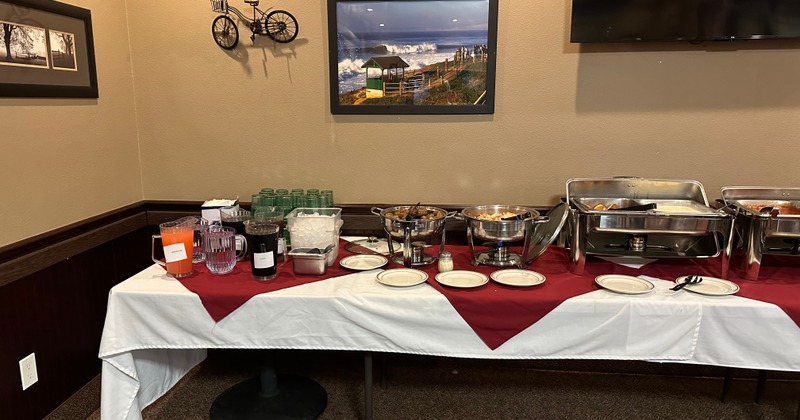 Buffet table with steam table and dishes available buffet style.