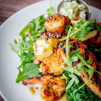 Grilled seafood platter with shrimp, grilled salmon, and arugula.