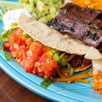 Carne asada taco served alongside rice, close-up.
