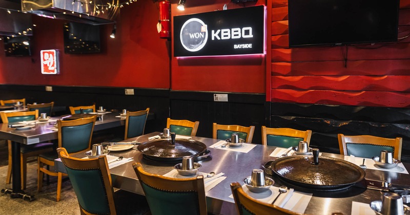 Closeup view of a set table, restaurant's sign on the wall