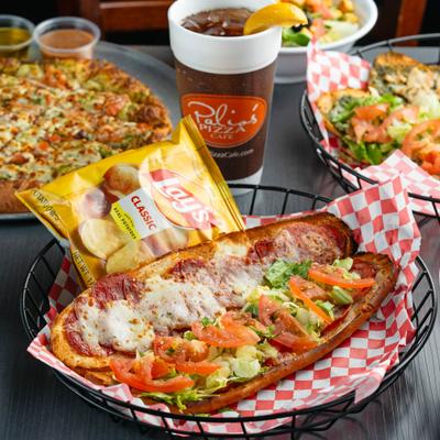 Hot Italian Sub with a bag of chips, served alongside other dishes and a cup of soda.