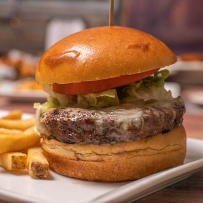 A cheeseburger on a brioche bun served with a side of fries.
