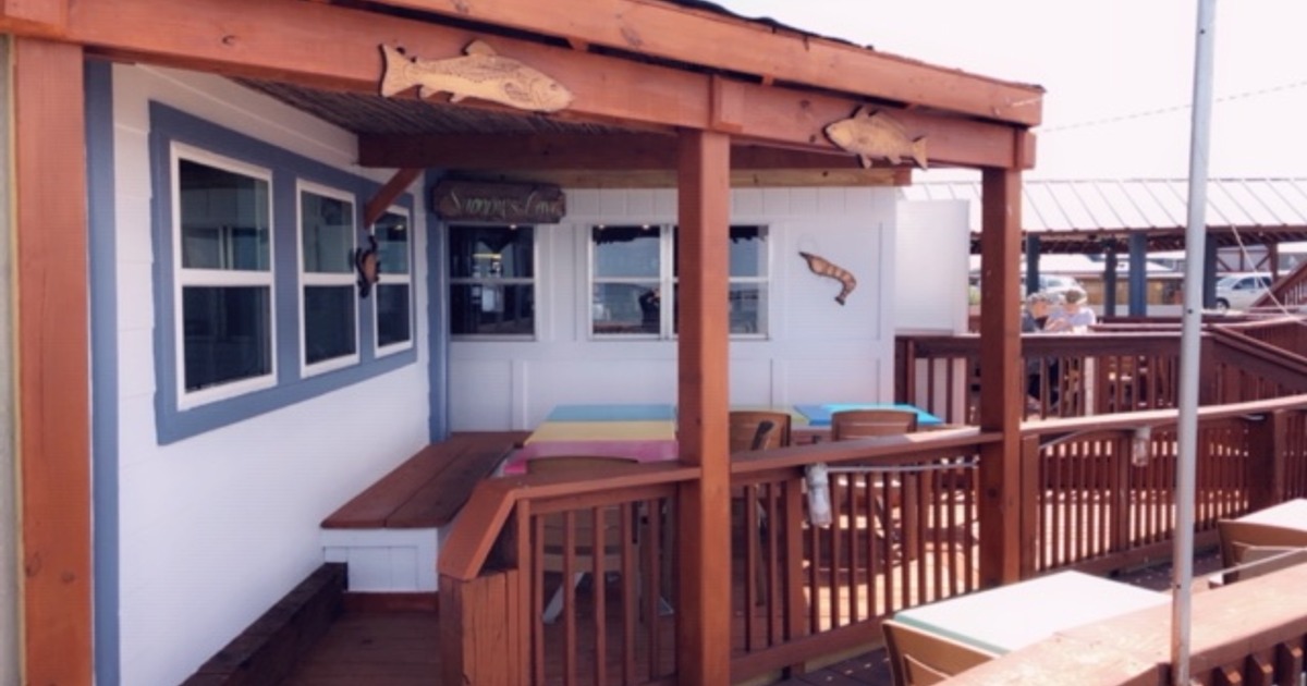 A porch with a wooden table and chairs