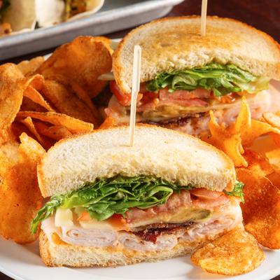 Avocado Cajun Club served with chips.