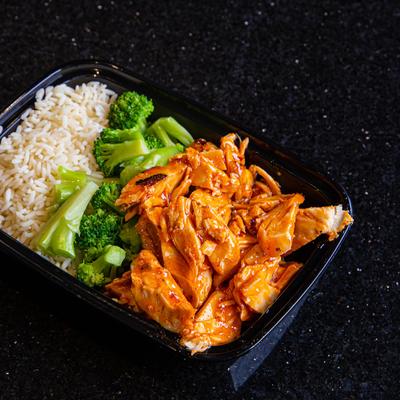 Sliced meat with sauce, vegetables and rice on the side