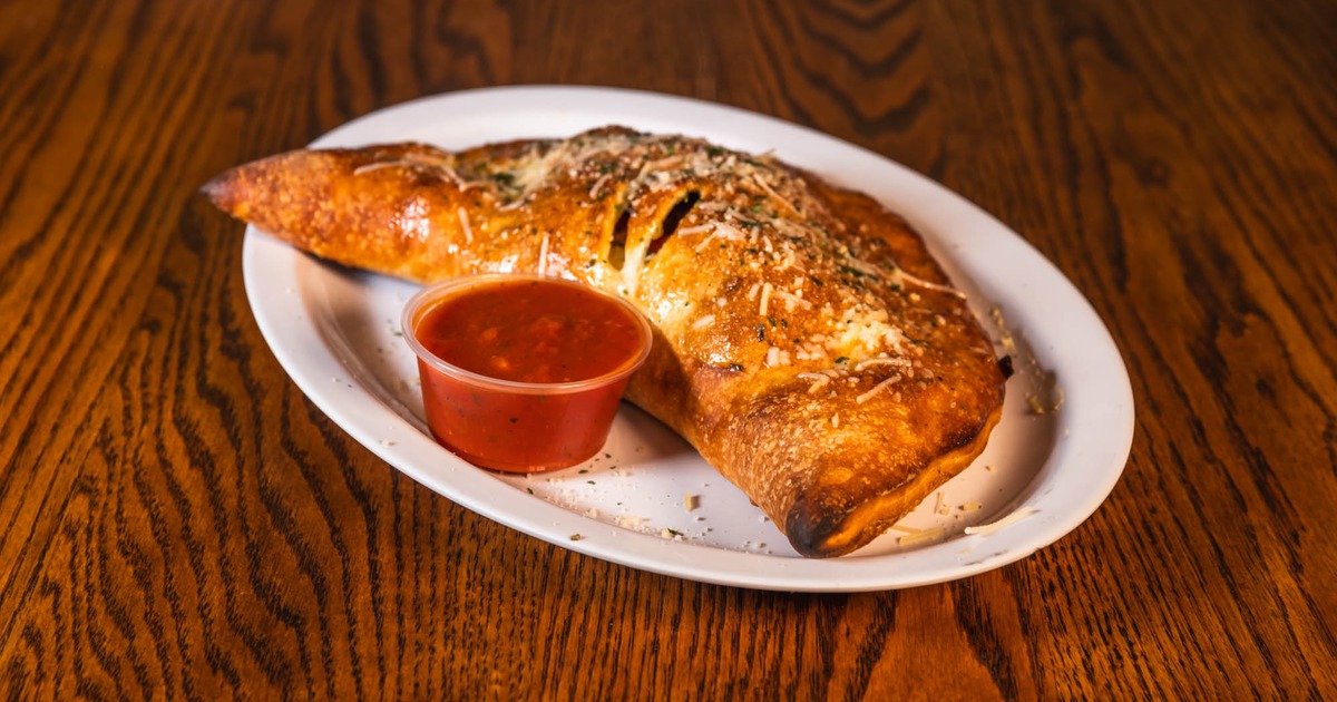 Calzone served with a red sauce
