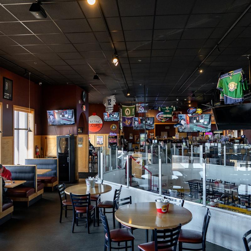 Interior of a sports bar with booths, tables, and sports memorabilia