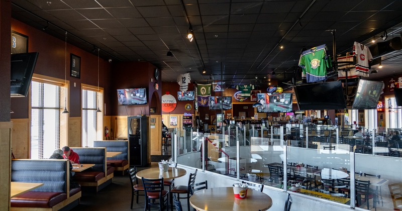 Interior of a sports bar with booths, tables, and sports memorabilia