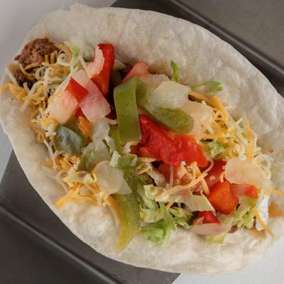 Ground beef taco, with mixed vegetables, and cheese.