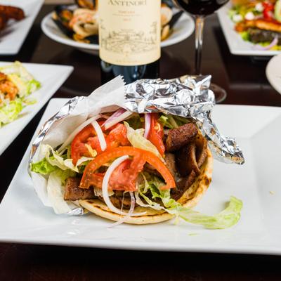 Stuffed pita gyro wrap on a white plate.