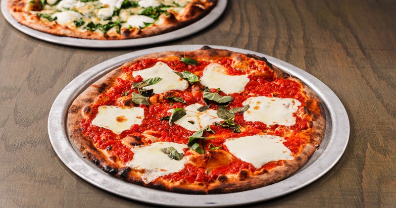 Two different pizzas served on the table