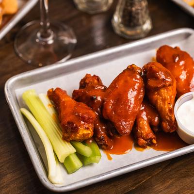 Buffalo wings with celery sticks and ranch dipping suace.
