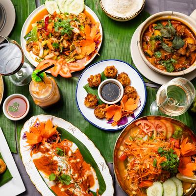 A table full of assorted food plates and drinks.