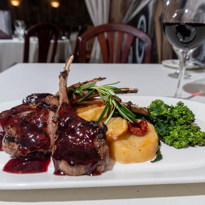 Lamb chops with blueberry and red wine reduction, roasted potatoes, and broccoli rabe