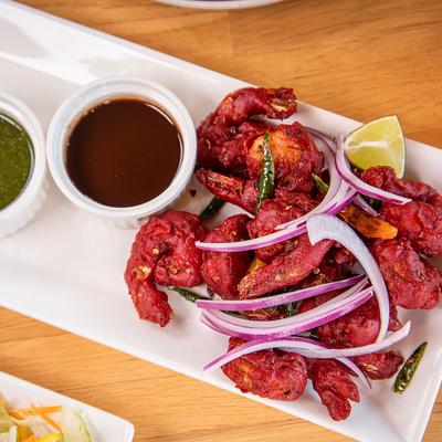 Shrimp 65 served with two small bowls of chutney.