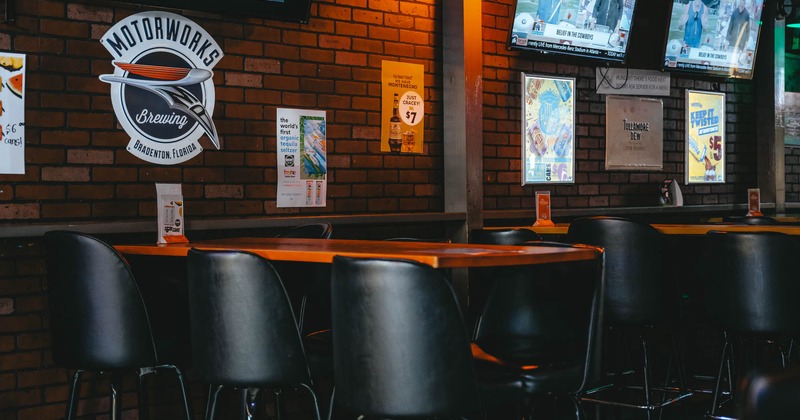 Interior, tall tables for six people and bar stools