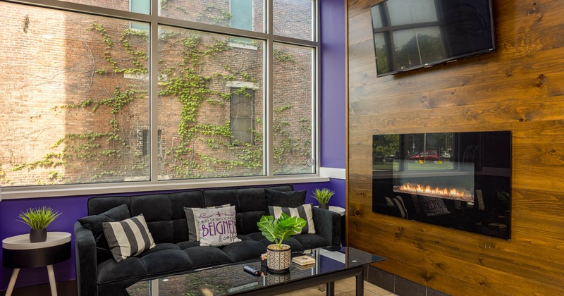 Interior, couch with coffee table, large window, TV, gas fireplace built in the wall