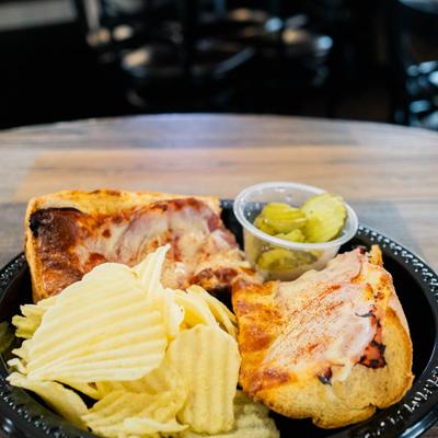 Gerber sandwich with sides of chips and pickles.