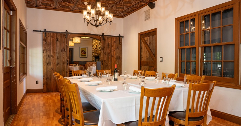 Elegant private dining room with a large table set for guests, perfect for a small dinner gathering